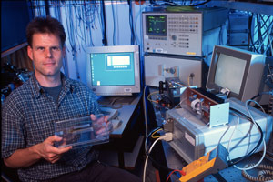 Bert Offrein, manager of the photonics group at IBM Research – Zurich, holds an example of silicon photonic chips integrated with an array of polymer waveguides. 