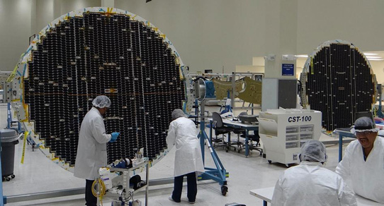 Spectrolab employees work to complete assembly of the Starliner solar panels in Sylmar.