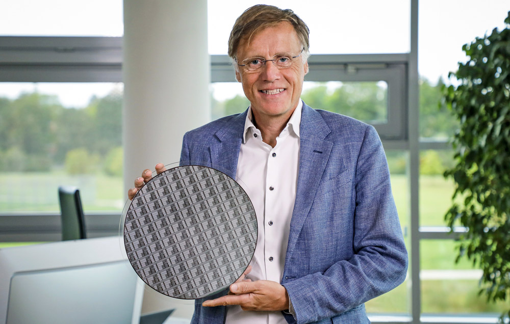 Infineon CEO Jochen Hanebeck holds one of the world’s first 300mm GaN power wafers produced in an existing and scalable high-volume manufacturing environment.