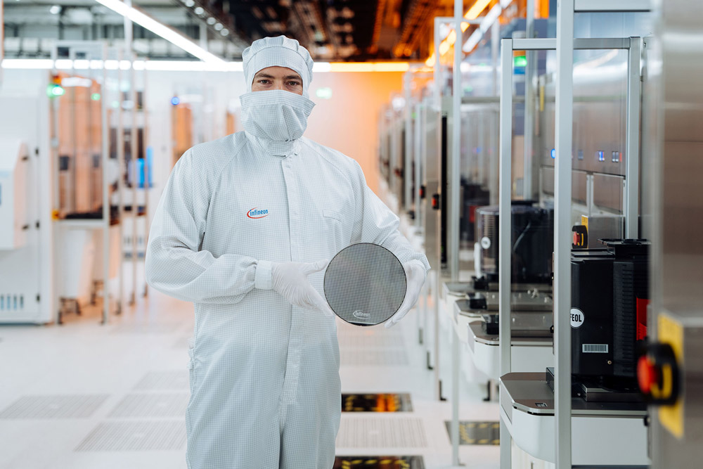 A technical engineer holding a 200mm silicon carbide wafer in the cleanroom of Infineon’s fab in Villach, Austria.